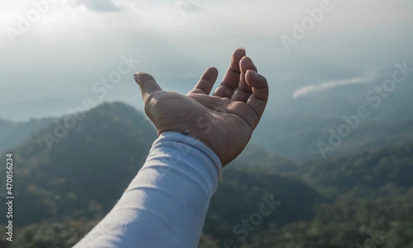 Fototapeta Hands outstretched to receive natural light and mountain views