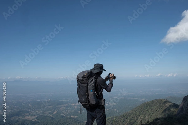 Fototapeta hikers traveling with backpacks taking pictures on the top of the mountain