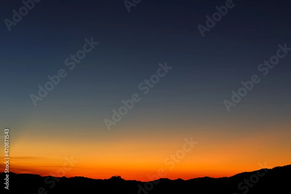 Fototapeta Heaven at early morning with copy space. Sunset, sunrise backdrop.Predawn clear sky with orange horizon and blue atmosphere. Smooth orange blue gradient of dawn sky.