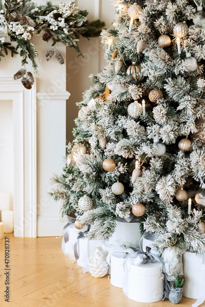 Obraz New Year's gifts under a snowy tree, beautiful white boxes with toys of light colors. Christmas presents. Fireplace.