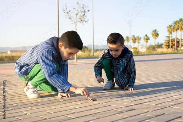 Fototapeta Two valencian brothers wearing a valencian fallas dress and playing with firecrackers