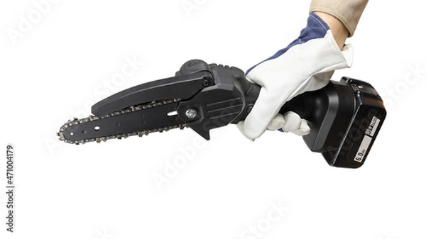 Fototapeta Hand in glove holds electric portable chain saw with battery, tool for working with wood, close-up isolated on white background