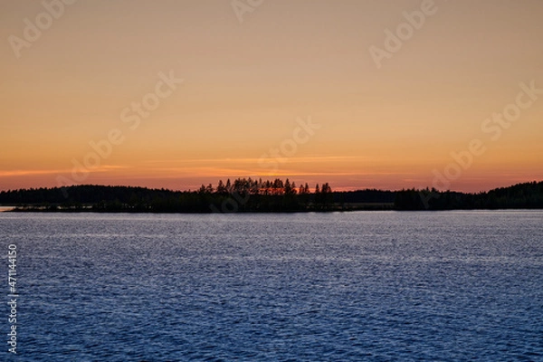 Fototapeta Russia. Onega lip of the White Sea. The sun went over the horizon behind the forest