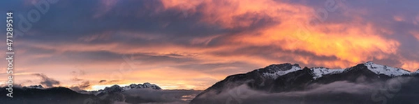 Obraz fog covered hahnenkamm mountain range with dramatic orange-red sky at sunset in late autumn