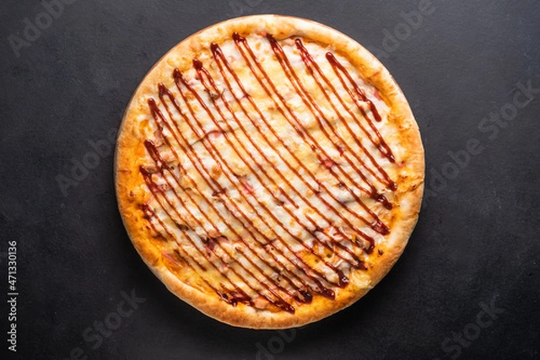 Obraz Round baked pizza with tomato, pepper, sausage, cheese on a black background. 