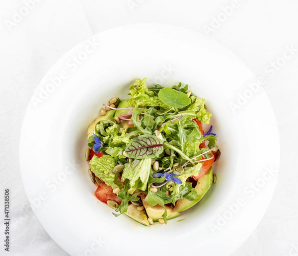 Fototapeta Salad with avocado and pine nuts. Isolated on a white background.