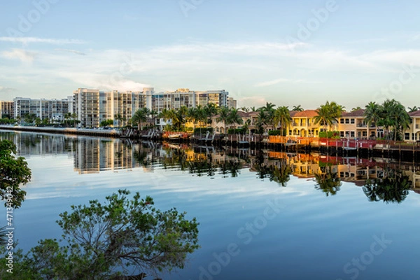 Fototapeta Hollywood beach in Miami, Florida with Intracoastal water canal Stranahan river and view of waterfront property modern mansions villas houses with palm trees reflection at sunset