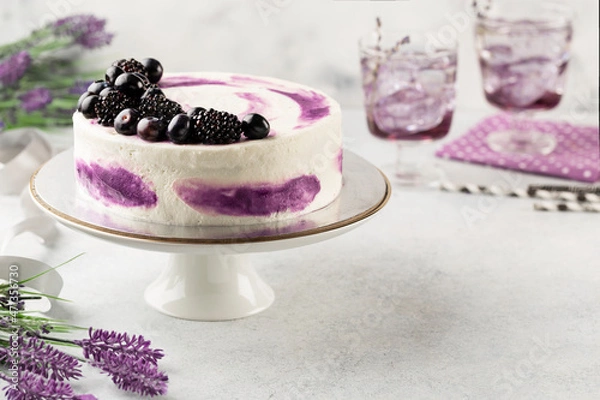 Fototapeta Beautiful tasty cake with white cream and blueberries on cake stand