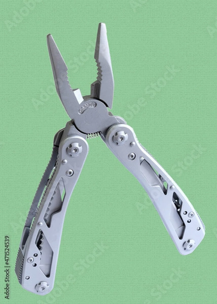 Obraz Miniature, pocket-sized universal Multi tool containing  knife, opener, pliers, scissors and a file.