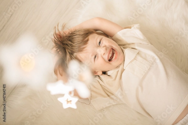 Fototapeta christmas atmosphere garland bokeh children reading a book asterisks light