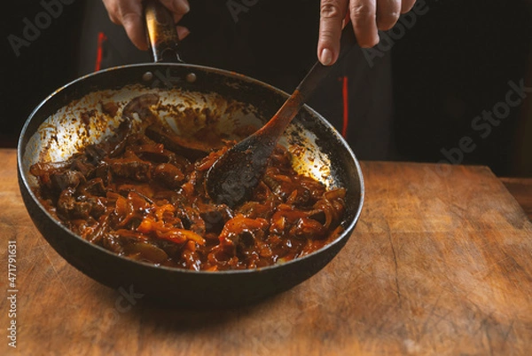 Fototapeta The cook prepares meat with vegetables and onion in a bowl . Oriental cuisine