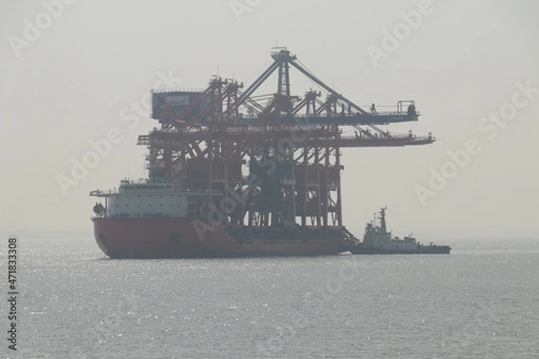 Fototapeta Grab Ship Unloader being transported in large vessel.