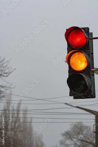 Fototapeta A traffic light showing both red and yellow lights at the same time. A traffic light showing two lights at the same time, warning and prohibiting.
