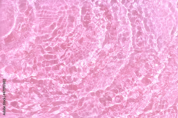 Fototapeta Transparent pink water background. Sun, shadows and ripples. Summer concept. Top view
