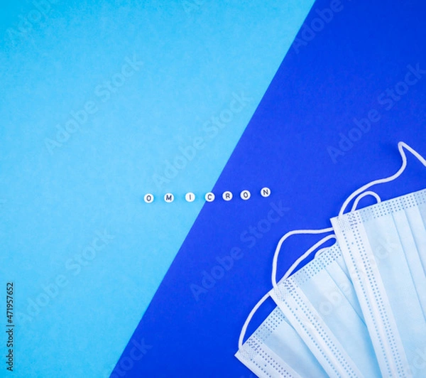Fototapeta Omicron variant of coronavirus text on blue and medical masks