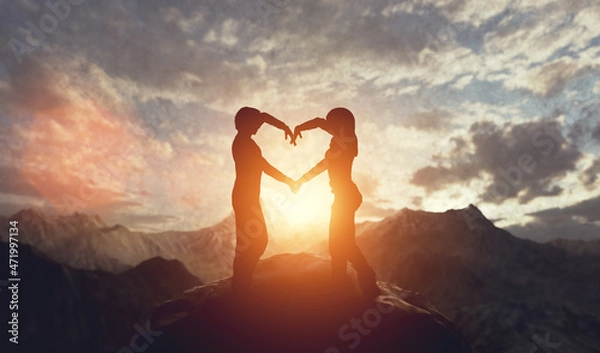 Fototapeta Couple in love making hart shape at sunset in mountains