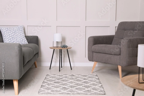 Fototapeta Stylish living room interior with grey rug and comfortable furniture