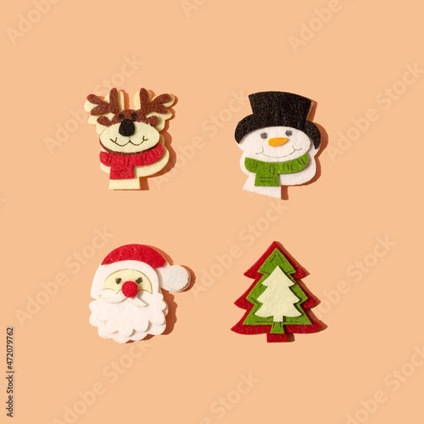 Obraz Christmas pattern made with ornaments: reindeer, snowman, santa claus and christmas tree on pastel peach background. Minimal fun and happy winter holidays and New Year idea.