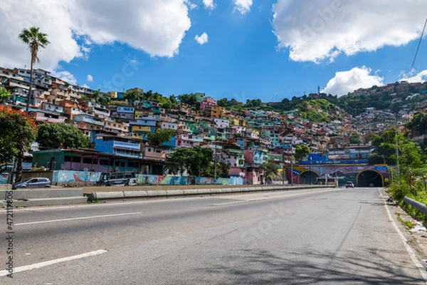 Fototapeta Caracas, Venezuela, 11.27.2021: view of the urban highway at the height of the tunnel "El Valle" with a popular suburb located on a hill.