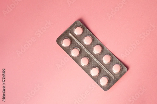 Obraz Pink pills in a blister pack on a pink background. 