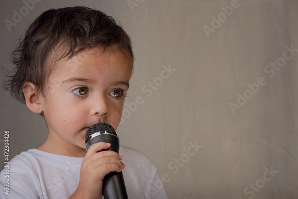 Fototapeta Little boy giving a speech with microphone