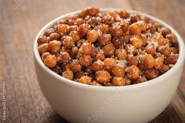 Obraz Close up bowl of roasted chickpeas with grated cheese on wooden table
