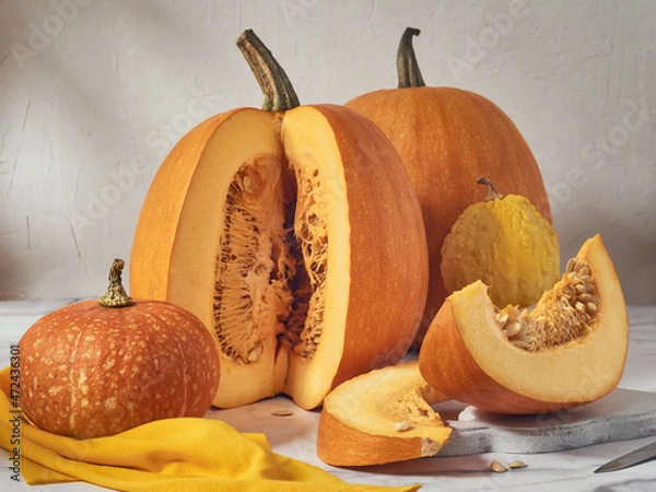 Fototapeta Orange pumpkins of various sizes on a light table