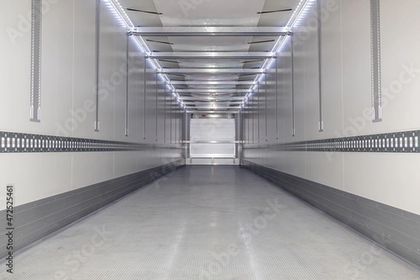 Fototapeta A big new empty refrigerated trailer inside. Inner space of the semi-trailer for transporting frozen food. Lighted cargo area for cargo placement. Lower angle shot