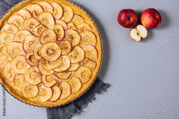 Fototapeta Top view of Classic french apple tart on a grey background with apples and cinnamon sticks