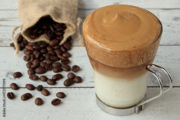 Obraz cup of dalgona coffee on wooden table with bag of natural coffee beans