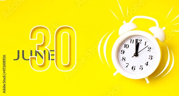 Fototapeta June 30th. Day 30 of month, Calendar date. White alarm clock with calendar day on yellow background. Minimalistic concept of time, deadline. Summer month, day of the year concept.