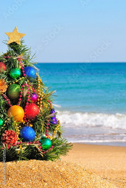 Fototapeta Christmas tree on the sand in the beach