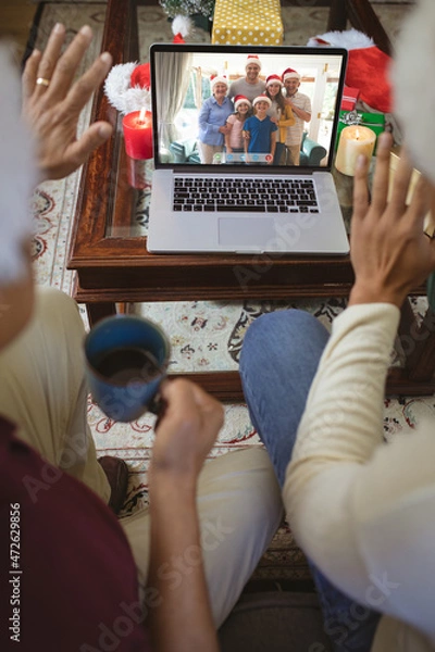 Fototapeta Two waving men making laptop christmas video call with smiling caucasian multi generation family