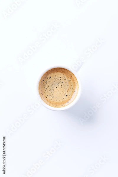 Fototapeta Cup of coffee on bright paper background. Top view. Close up. Copy space.	