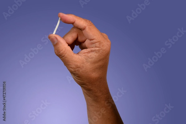 Obraz hand in rubber gloves holding a hormonal implant.