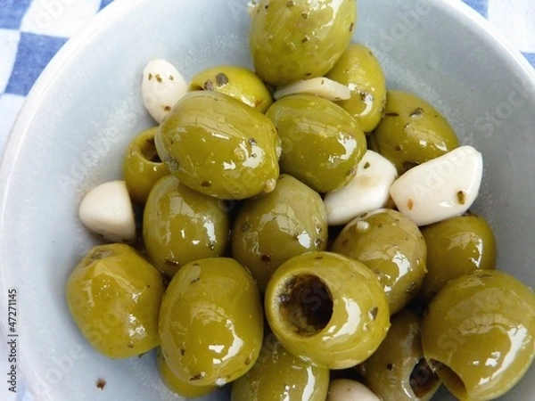 Obraz Green olives with garlic in a bowl