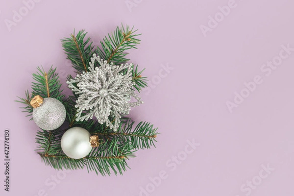 Fototapeta Spruce branches and christmas ornaments on a violet background. Christmas background.