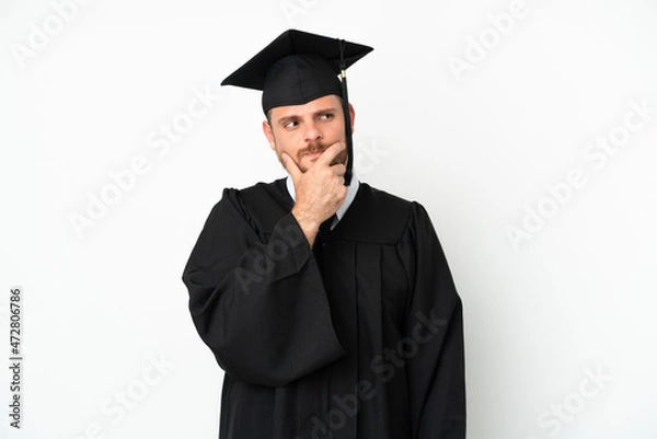Obraz Young university Brazilian graduate isolated on white background having doubts