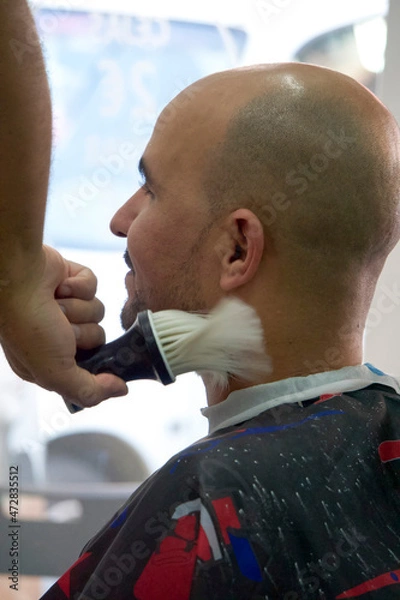 Obraz Barber cleaning his client neck with brush at barbershop.
