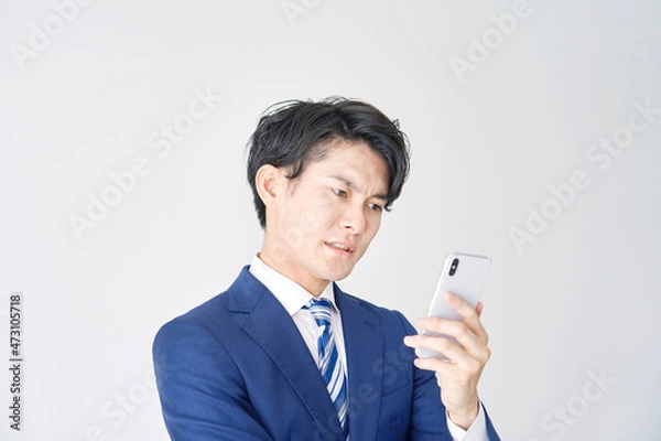 Fototapeta ビジネスマン　スマホ　白背景　考える