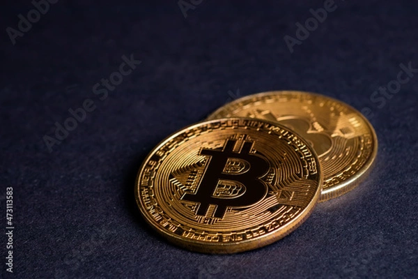 Fototapeta Close up of golden coins with bitcoin symbol background.