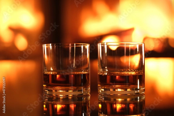 Obraz Two glasses with whiskey on the fireplace background. 