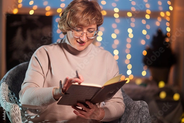 Obraz woman writes a wish list on christmas night. concept Goals plans make to do and wish list for new year christmas concept, girl writing in notebook.