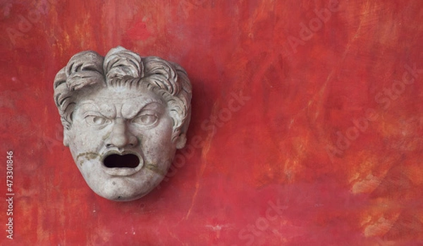Fototapeta Copy of an antique theatre mask isolated on a red background