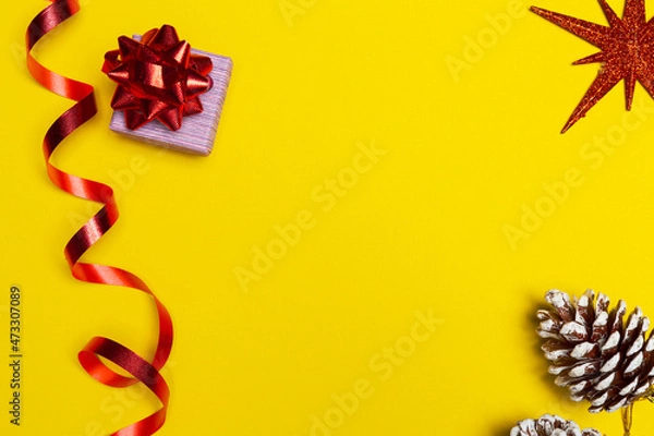 Fototapeta Gift box with a red bow on yellow background with free space for greetings. New year gift, space for present list.