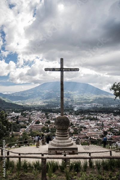 Fototapeta A cross in front of a volcano in Antigua, Guatemala. 