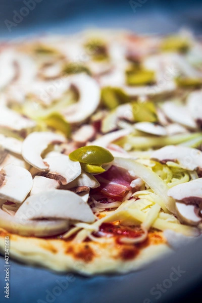 Fototapeta Home-made pizza with .champignons, onion, olives and bacon before baking.