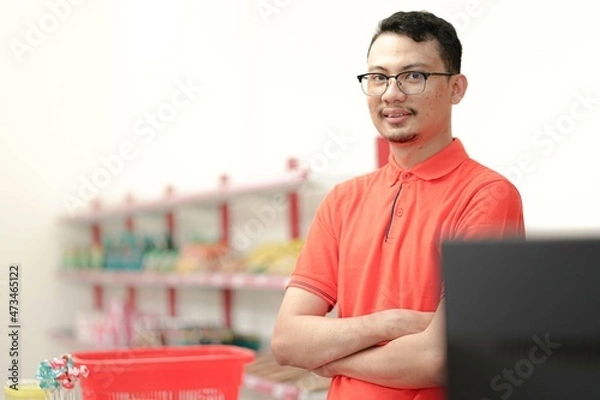Obraz Asian young man chasier wear uniform smiling at the camera