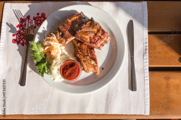 Fototapeta Shish kebab pork ribs on a plate, outdoor cafe, top view