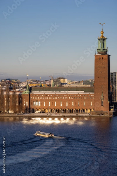 Fototapeta Panorama of Stockholm city on a sunny winter day photographed from the hill. City hall with touristic boat in front. Capital of Sweden